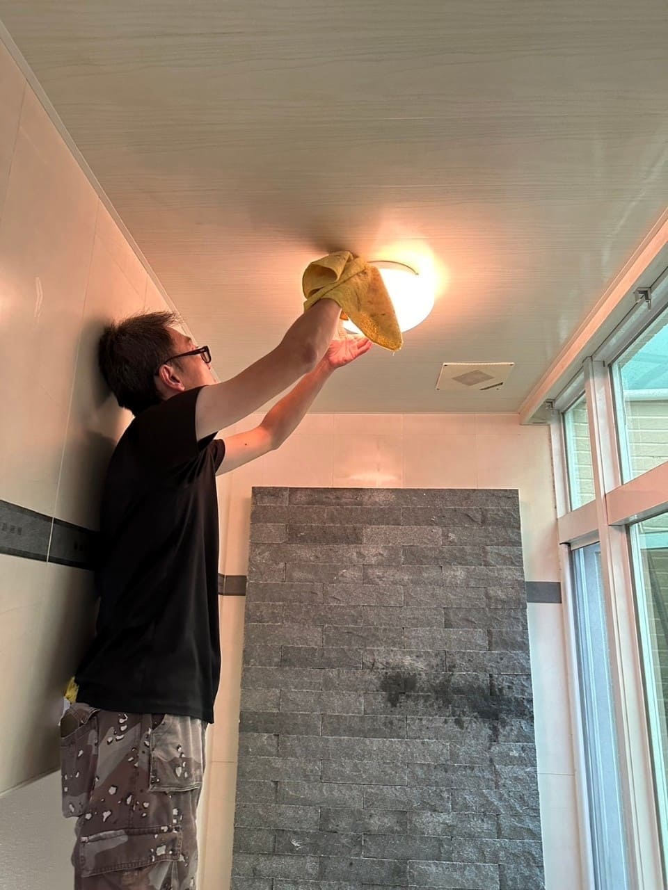 清潔師傅處理浴室天花板與燈具周邊